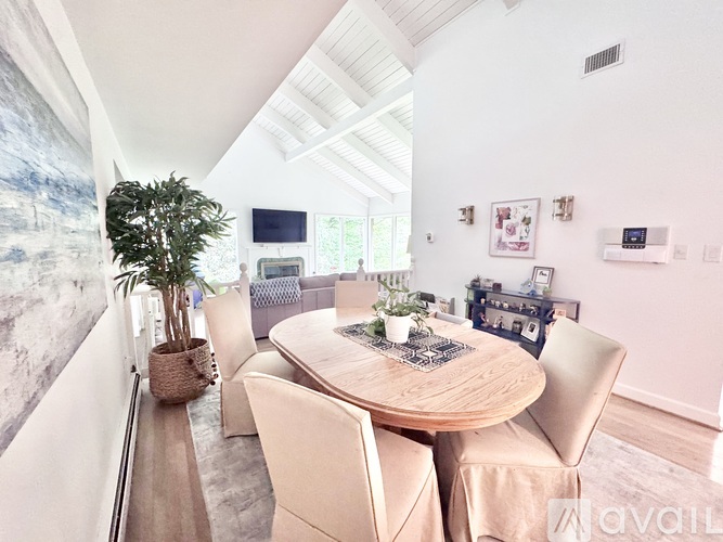 A dining room with a round table surrounded by chairs.