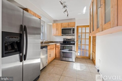 A modern kitchen with a stainless steel refrigerator and wooden cabinets.