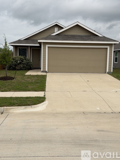 A house with a grey garage door and a brown roof.