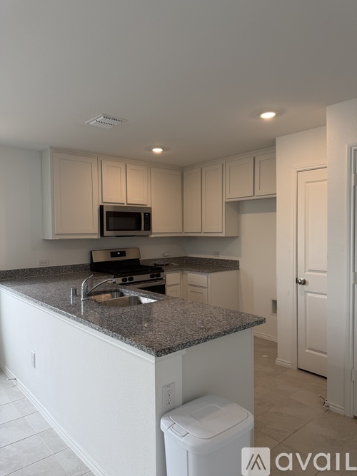 A kitchen with granite countertops and white cabinets.