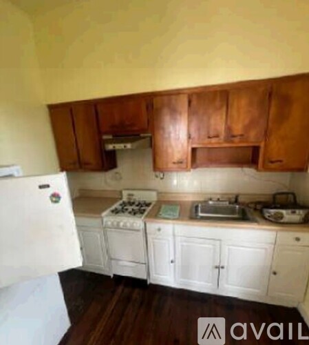 A kitchen with white appliances and wooden cabinets.