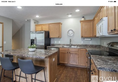 A kitchen with wooden cabinets and a granite countertop.