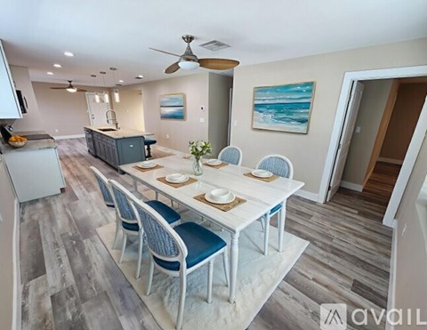 A dining room with a white table and blue chairs.