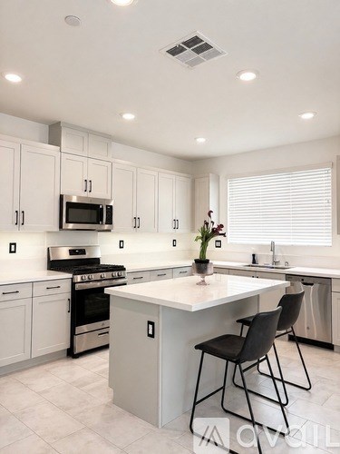 A modern kitchen with white cabinets and a central island.