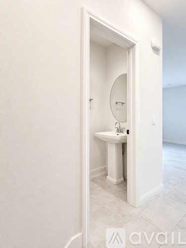A white bathroom with a sink and mirror.