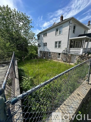 A white house with a fence in front of it.