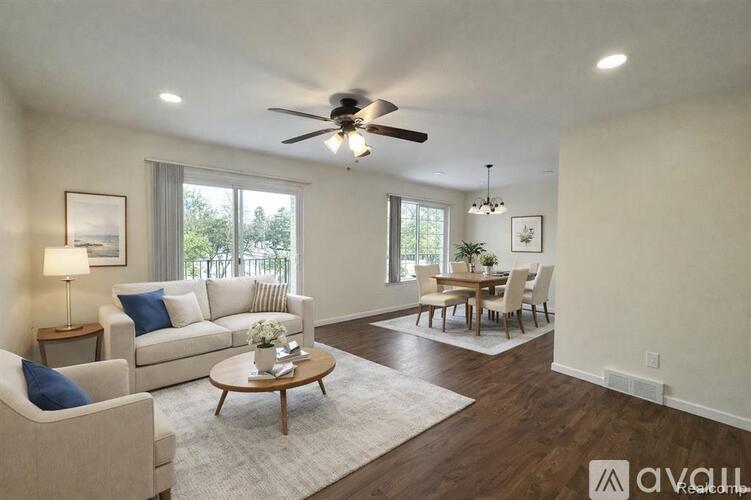 A living room with a white couch, a coffee table, and a dining table with chairs.