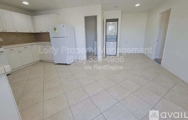 A kitchen area with a refrigerator, cabinets, and a countertop.