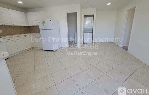 A kitchen area with a refrigerator, cabinets, and a countertop.