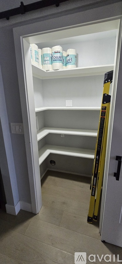 A white refrigerator with three bottles on the top shelf.