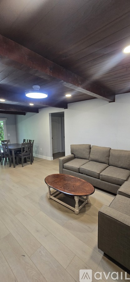 A living room with a brown couch and a wooden coffee table.
