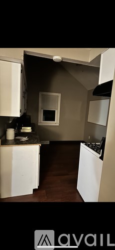 A kitchen with white cabinets and a black stove top.