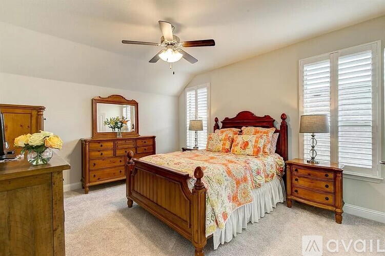 A bedroom with a bed, dresser, and mirror.