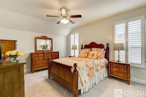 A bedroom with a bed, dresser, and mirror.