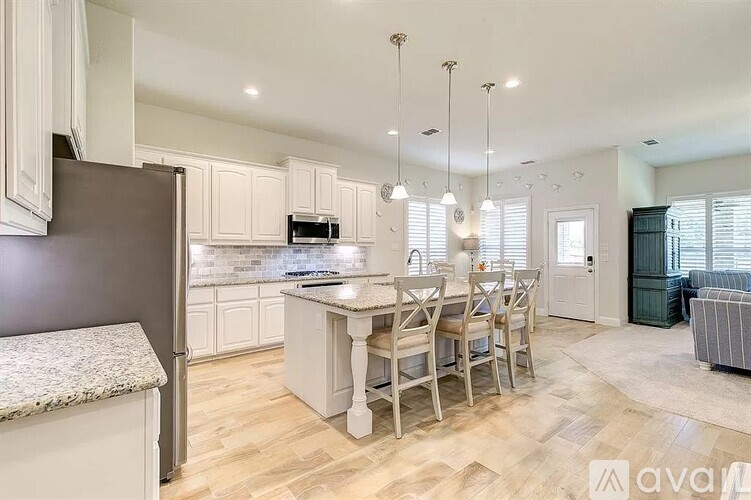 A kitchen with a table and chairs in the middle of the room.