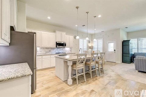 A kitchen with a table and chairs in the middle of the room.