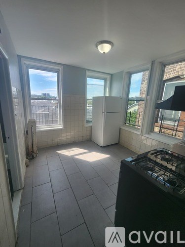 A kitchen with a black stove top and a white fridge.