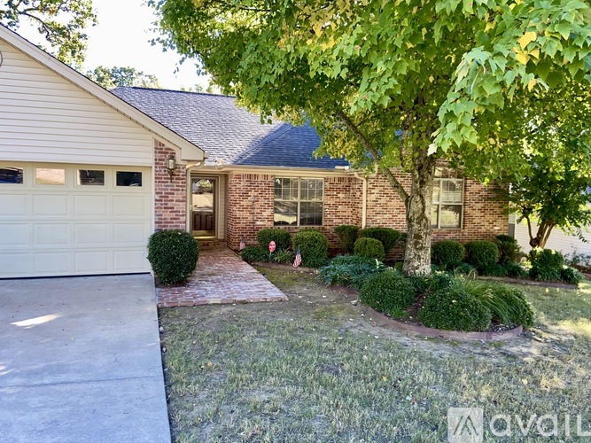 A house with a driveway and a tree in front.