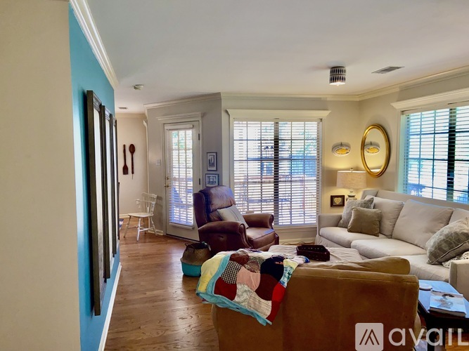 A living room with a brown couch and a white couch.
