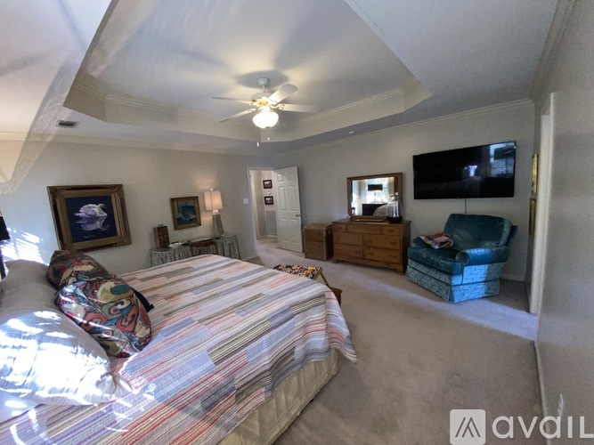 A bedroom with a bed, a chair, and a television.