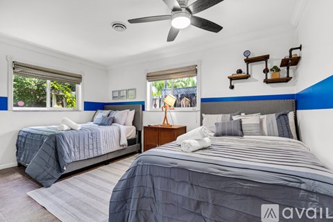 Two bedrooms with blue and grey bedding and a ceiling fan.
