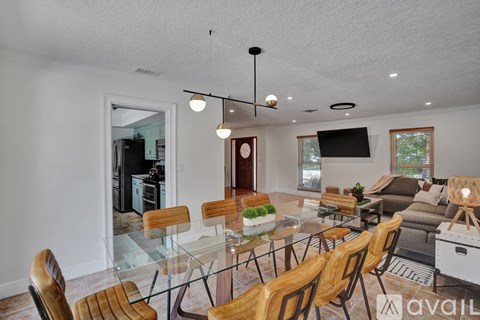 A modern dining room with a glass table and chairs.