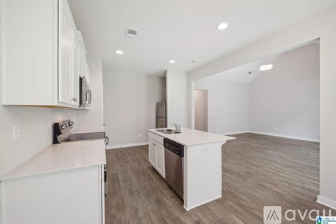 A kitchen with white cabinets and a white countertop.