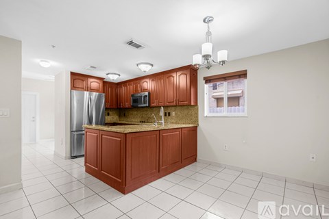 A kitchen with brown cabinets and a white tile floor.