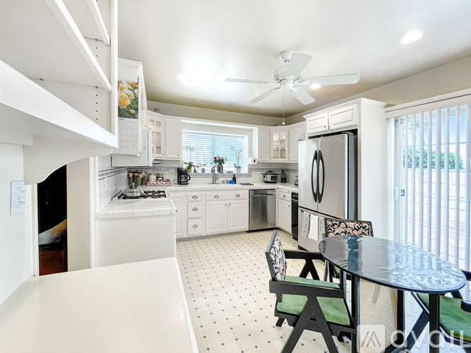 A kitchen with a table and chairs in front of a window.