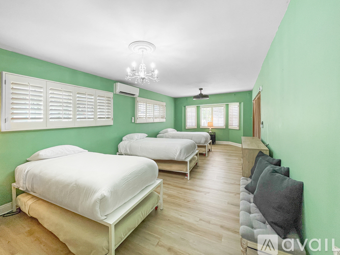 A bedroom with two beds and a chandelier.