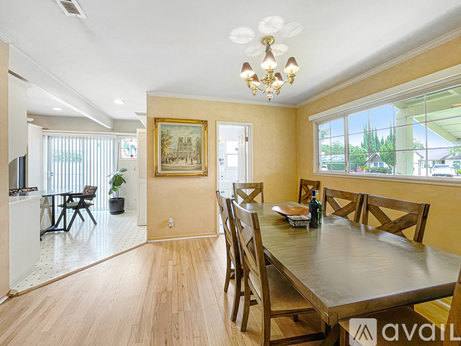 A dining room with a wooden table and chairs.