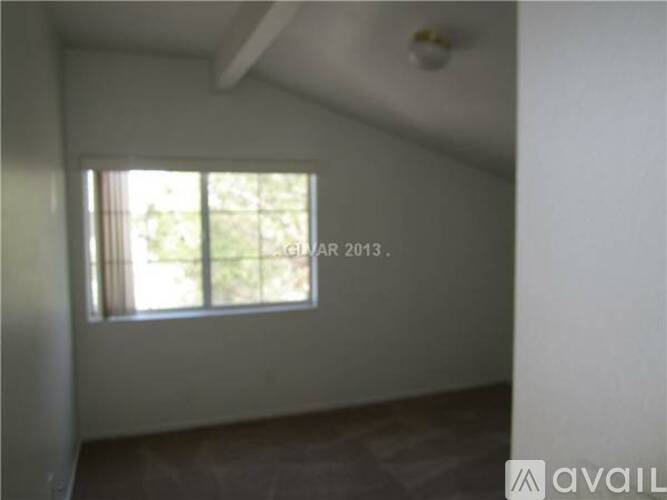 A room with a window and a wooden floor.