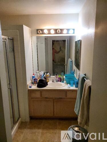 A bathroom with a sink, mirror, and a towel hanging on the wall.