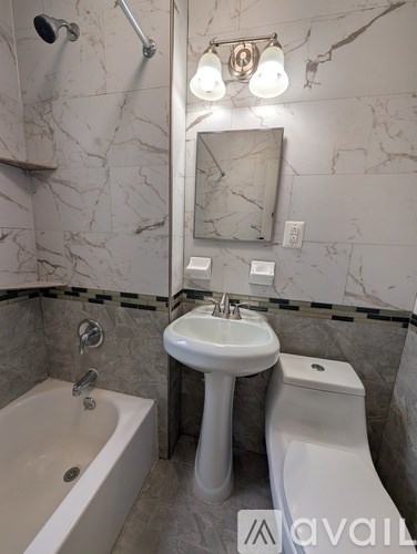 A bathroom with a marble wall and a white sink.