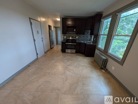 A kitchen with dark wood cabinets and a refrigerator in the background.