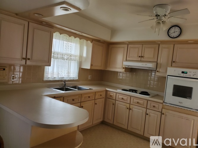 A kitchen with wooden cabinets and a white countertop.