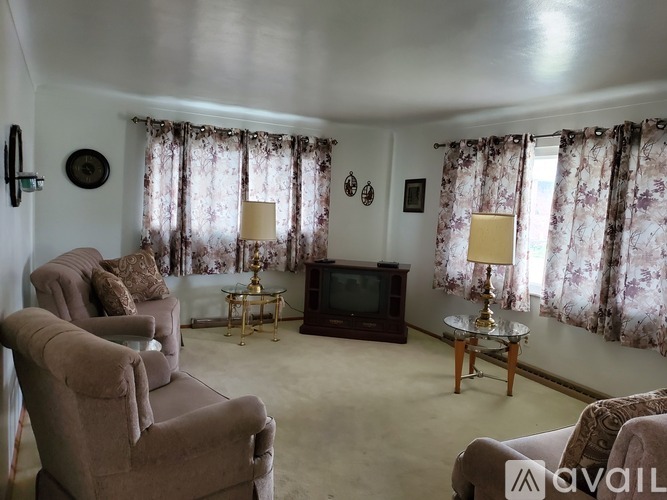 A living room with a sofa, armchairs, and a coffee table.