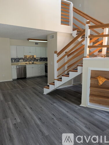 A wooden staircase with a white railing leads to a second floor.