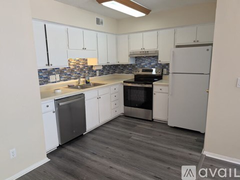 A kitchen with white cabinets and a tiled backsplash.