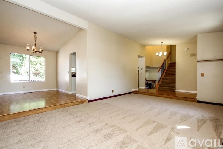 A spacious living room with a staircase leading to the upper floor.