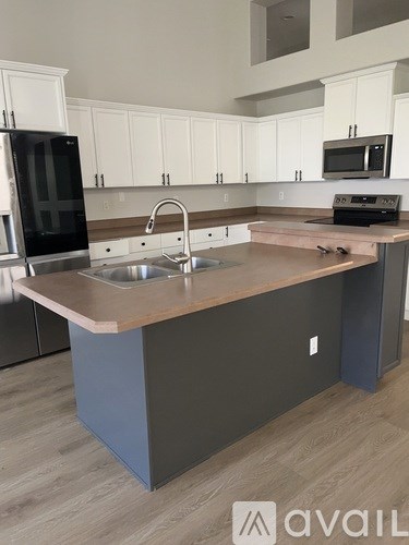 A kitchen with a sink and a refrigerator.