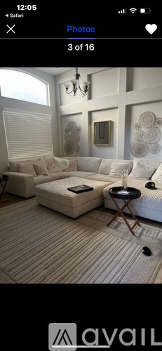 A living room with a white couch and a chandelier.