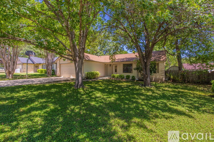 A house with a lawn and trees in front of it.