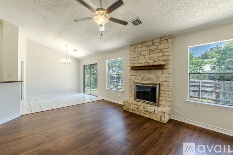 A room with a fireplace and a ceiling fan.