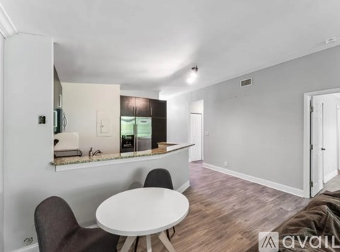 A living room with a white table and brown chairs.
