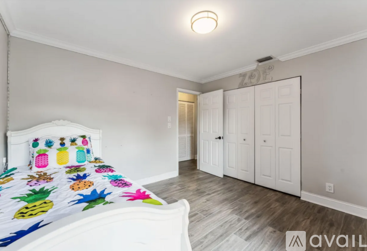 A bedroom with a bed and a pineapple bedspread.