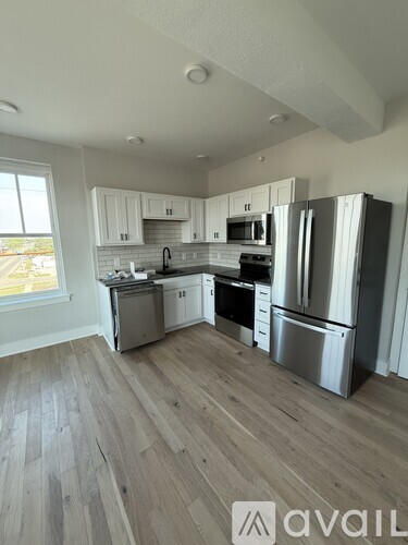 A kitchen with wooden floors and stainless steel appliances.
