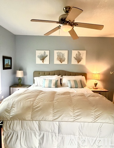 A bedroom with a large bed and a ceiling fan.