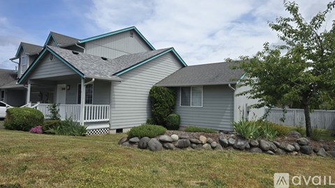 A house with a grey exterior and a white picket fence.