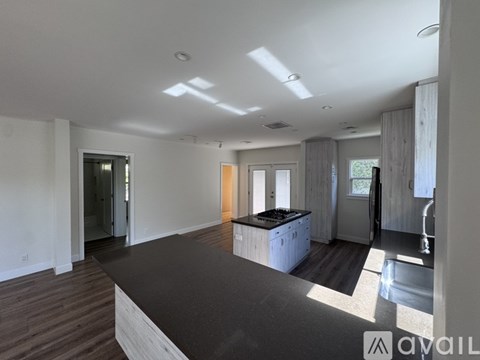 A spacious living room with a kitchenette and a dining area.